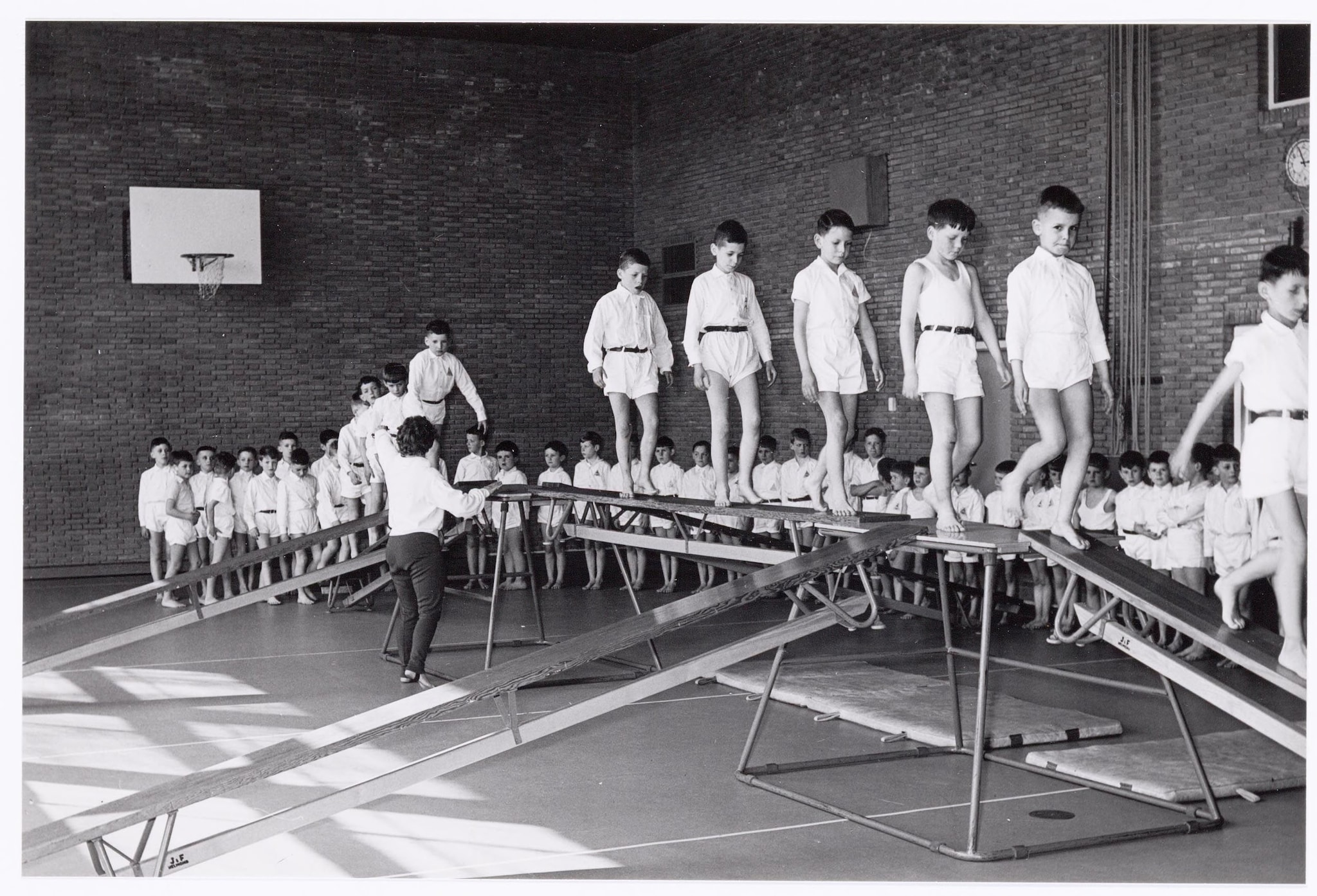 Een grote evenwichtsbalk, gemaakt van banken, was 50 jaar geleden regelmatig onderdeel van de gymlessen. Regionaal Archief Tilburg