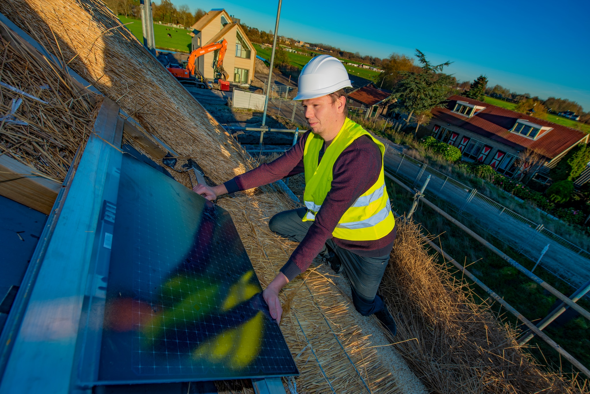 Een monteur plaatst de bijzondere zonnepanelen op het dak van een woning. Daniella Van Bergen