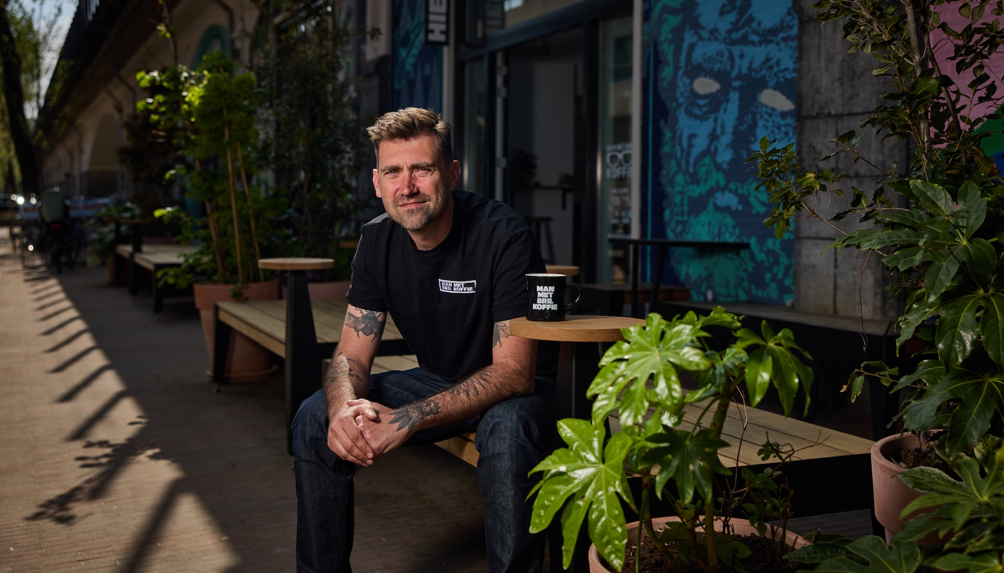 Paul Sharo van Man met Bril koffie op het terras van zijn zaak aan de Vijverhofstraat Jan de Groen