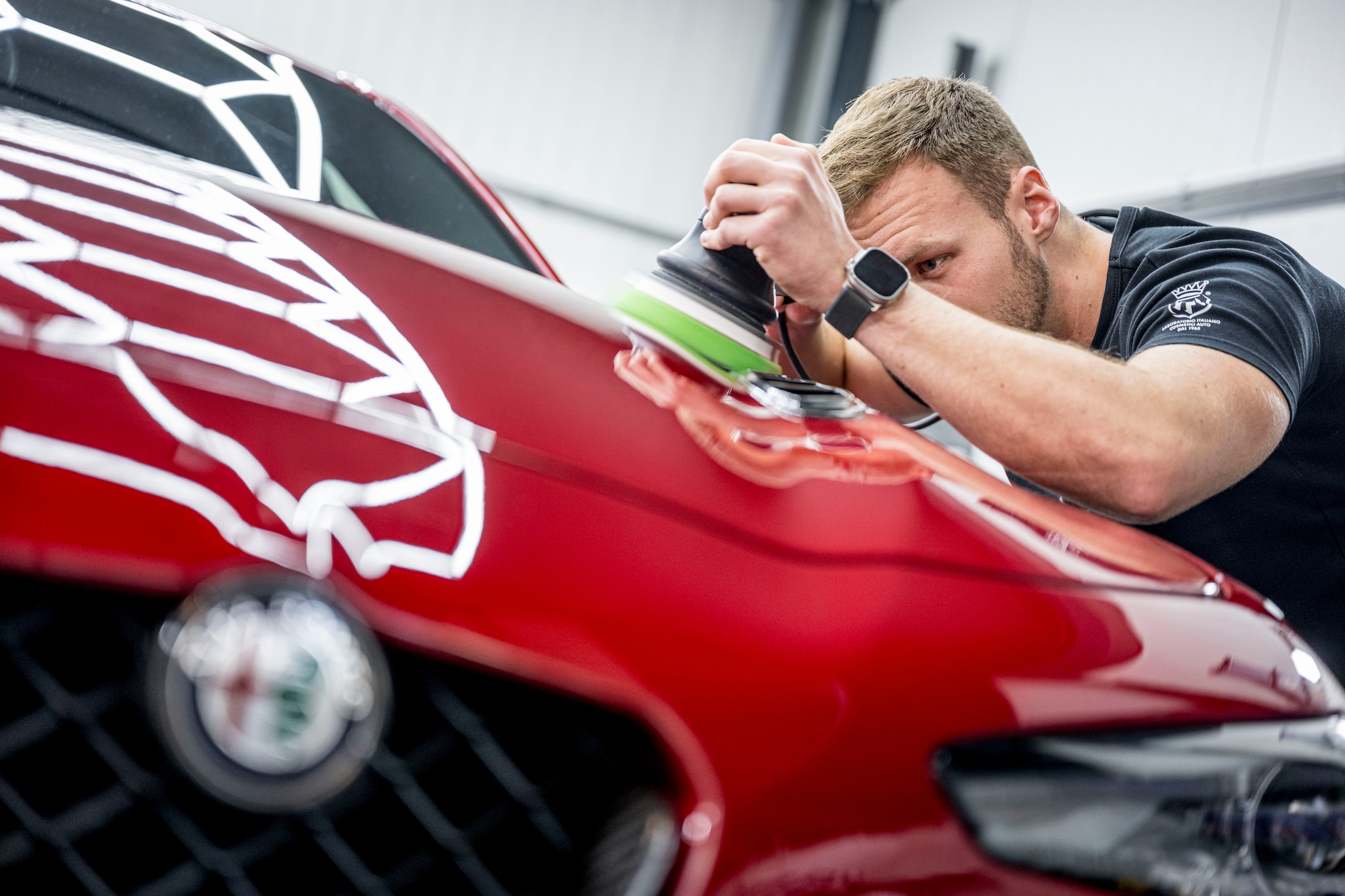 Sam Steneker polijst de Alfa Romeo Giulia van een van zijn klanten. Emiel Muijderman