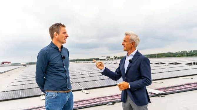Toine van de Ven laat Jaap Jongbloed de panelen op het dak zien. Met 7850 zonnepanelen op het dak van de enorme productiehal, draait Capi Europe energieneutraal.