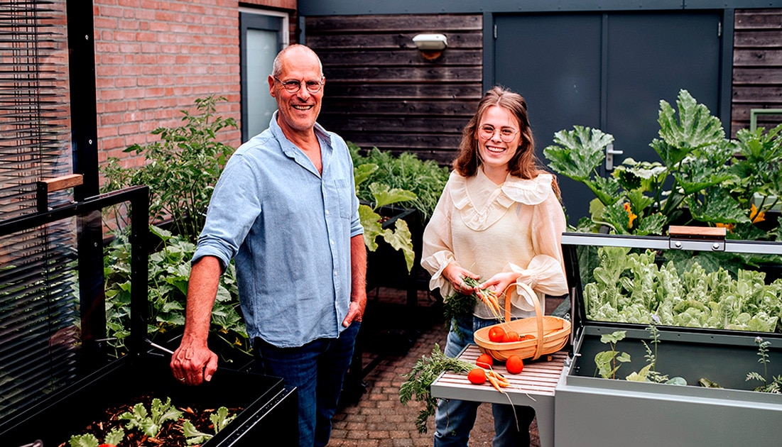 Beeld Leo (l) en Laura Nelis van The Garden Sidekick . Ze staan tussen twee van hun producten.Beeld Foto: The Garden Sidekick