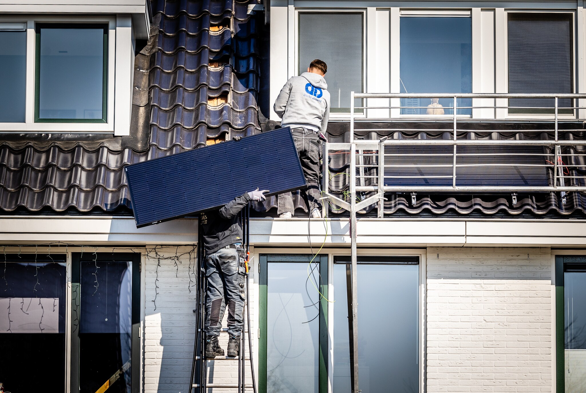 Zonnepanelen worden op het dak van een woning geïnstalleerd. ,,Zelfs als je geen duurzaamheidsagenda zou hebben is het een superieure energiebron.'' ANP /  ANP