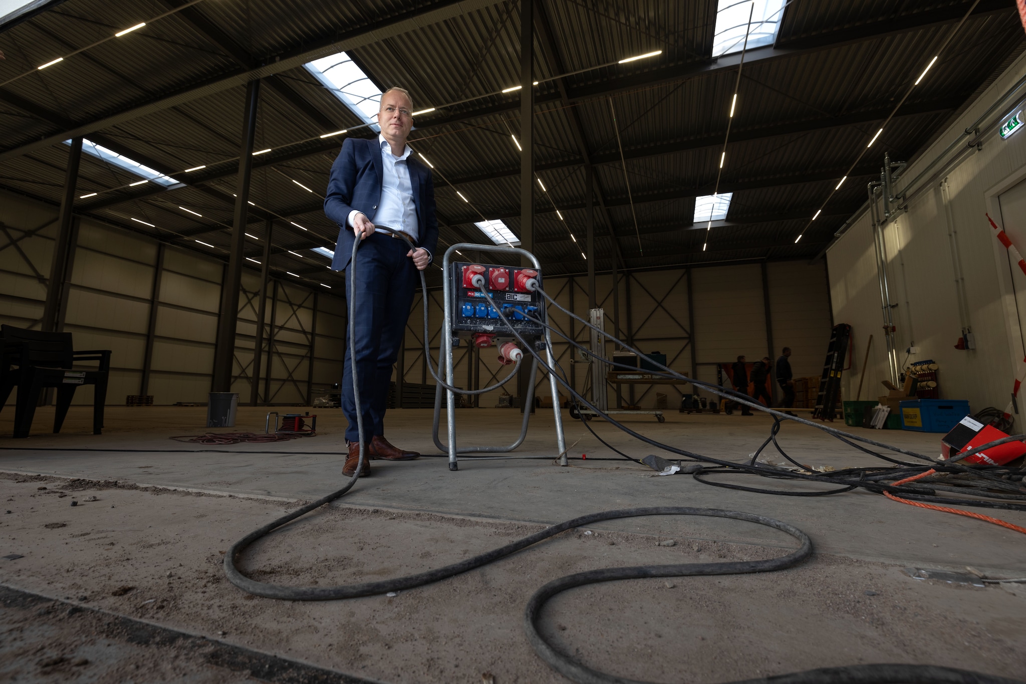 Arnoud Booij in de nieuwe bedrijfshal van zijn bedrijf ASF Fischer. Het licht brandt er dankzij een verlengsnoer. Foto Freddy Schinkel