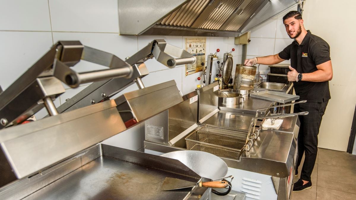 Joseph Elio demonstreert hoe het frituren van ‘kip-tenders’ gaat. Foto: Reinier van Willigen