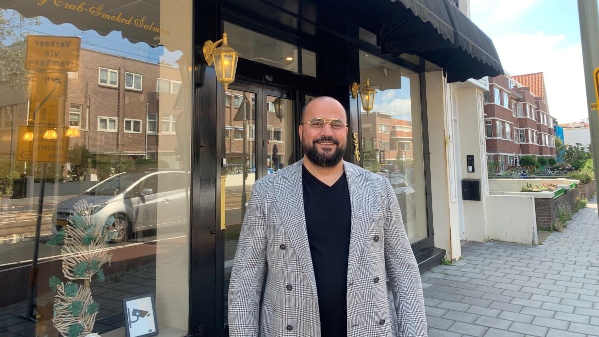 Ondernemer Hossein Akef voor zijn zaak. Foto: Indebuurt.nl