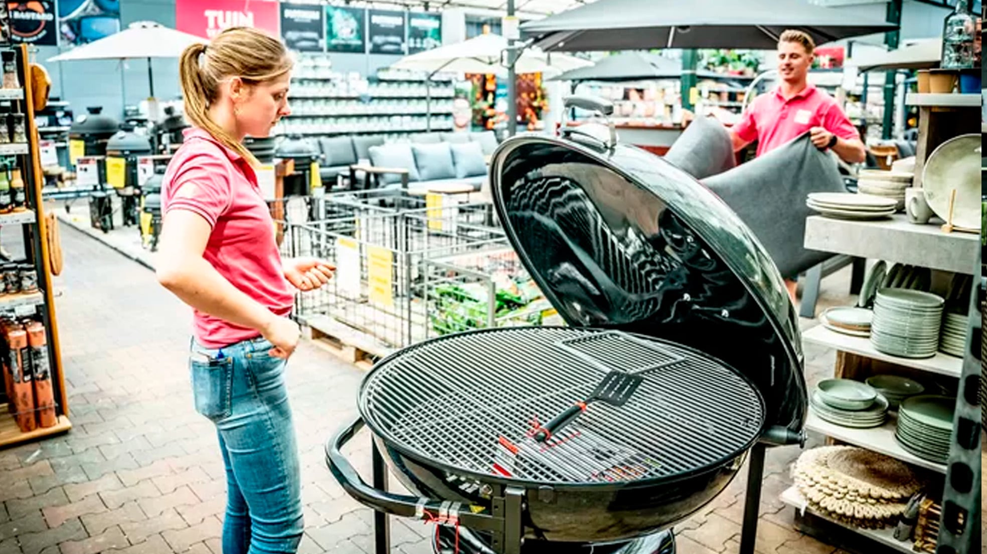 Sanne Gommers met een flink model barbecue. Op de achtergrond haar broer Bram. De twee zijn eigenaar van Tuinwereld Wijchen. Vorige week werd op klaarlichte dag een dure barbecue van de parkeerplaats van het bedrijf gestolen.  Eveline van Elk