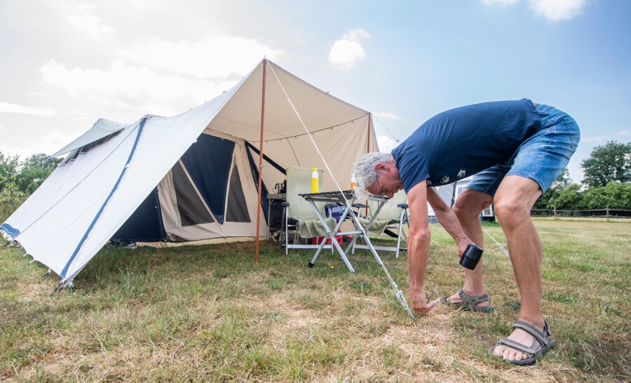 De romantiek van het kamperen. Hans Oosterloo (70) uit Harderwijk staat met vouwwagen en tent op De Heidebloem. Foto: Lenneke Lingmont