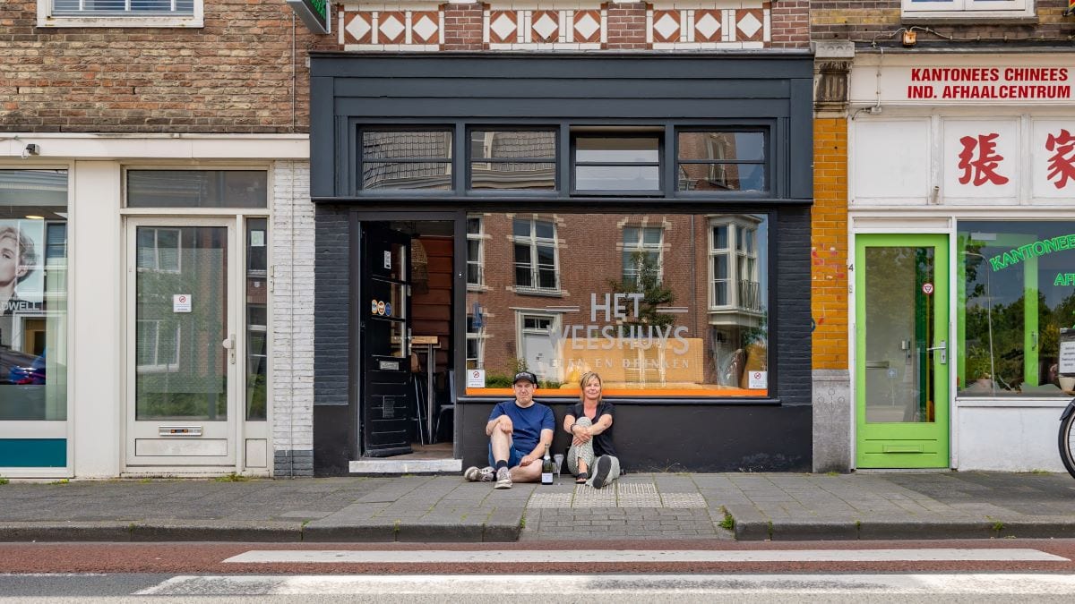 Eigenaren Peggy Damen en Robert van Thulden voor hun restaurant aan het begin van Assendorp. Het Weeshuys krijgt een na de herinrichting van de Kop van Assendorp eindelijk een terras. ,,De glazen staan klaar, menukaart is samengesteld, maar het ontkurken van de champagne laat nog even op zich wachten.” Foto: Pedro Sluiter
