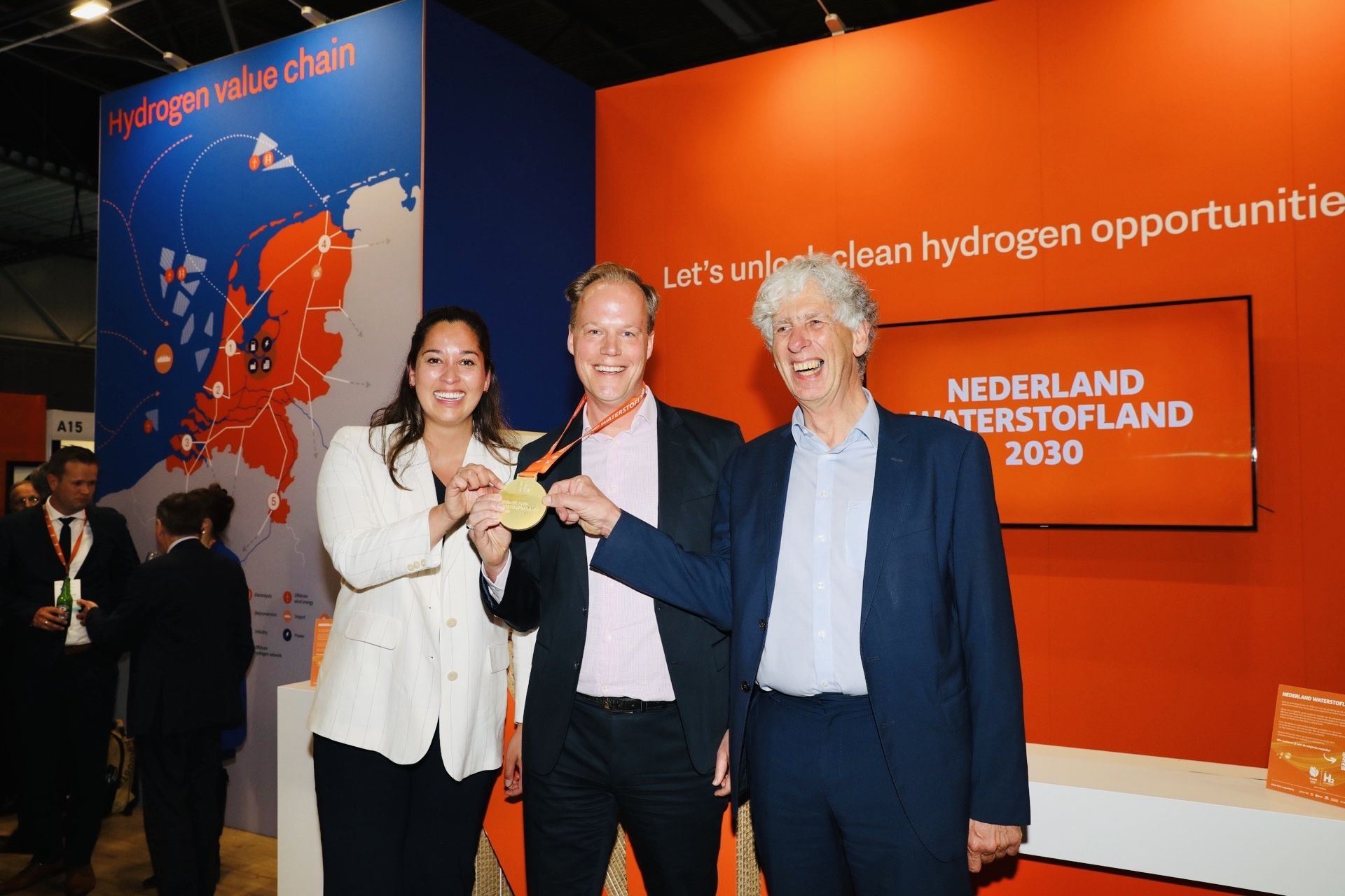 Ranomi Kromowidjojo reikte de eerste waterstofmedaille uit aan ondernemer Marcel Galjee (midden) van HyCC uit Amersfoort. Rechts Ulco Vermeulen, initiatiefnemer en bestuurslid van Missie H2.