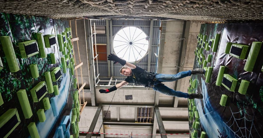 Ernst-Jan Swarte demonstreert Spider City, een attractie waarbij je kunt klimmen en tussen wanden springen als Spiderman. Foto: Jan de Groen