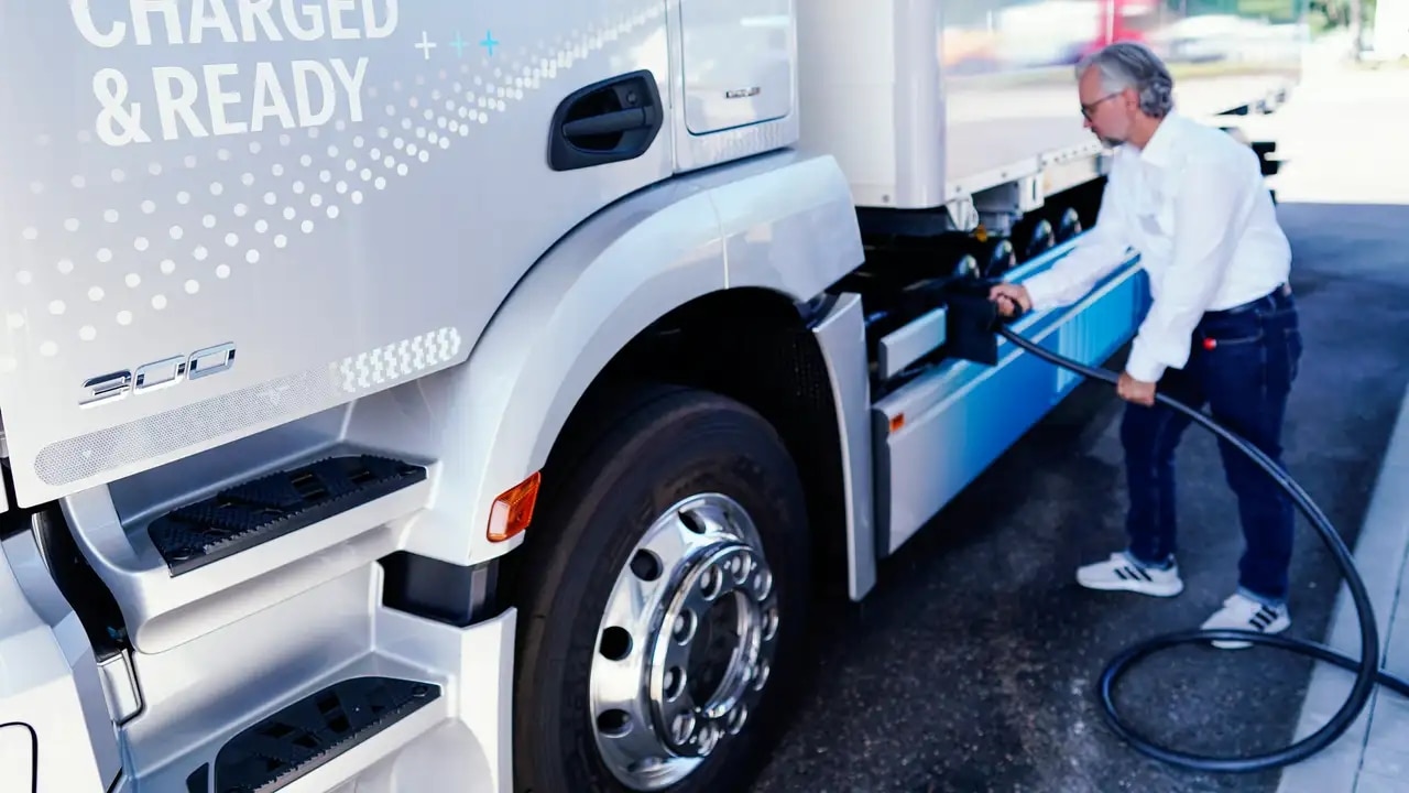 Een chauffeur laadt zijn elektrische vrachtwagen.