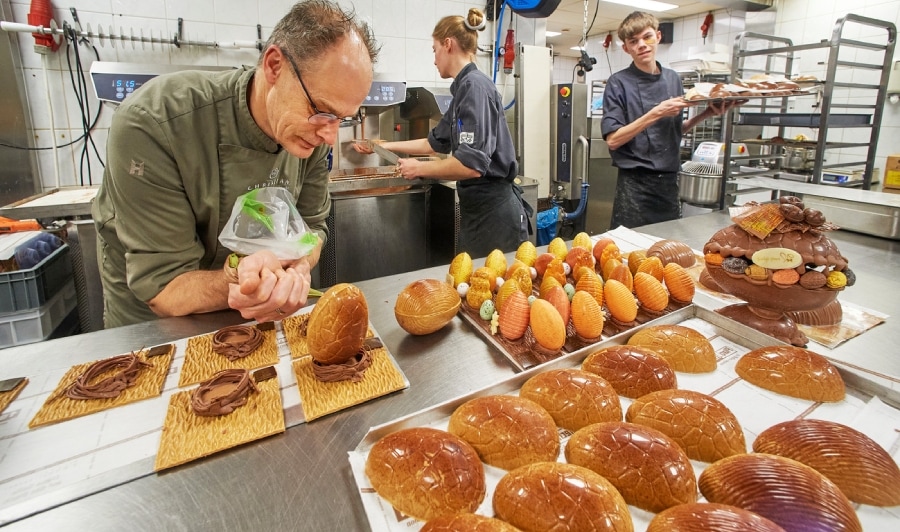 Christian van Kempen (l) druk aan het werk in zijn chocolaterie en patisserie met medewerkers Noor(m) en Jelle(r). Foto: Van Assendelft Fotografie