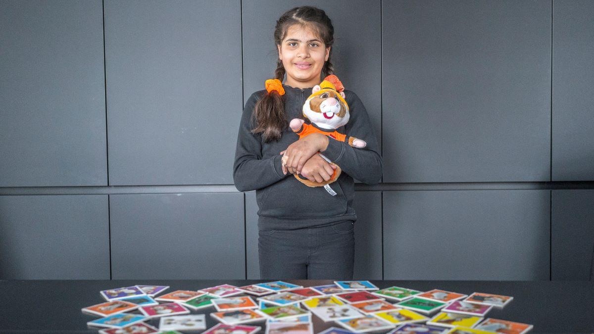 Sofie Graafland met haar hamster, voor haar op de tafel ligt het memory-hamsterspel van Albert Heijn. Foto: Fred Leeflang