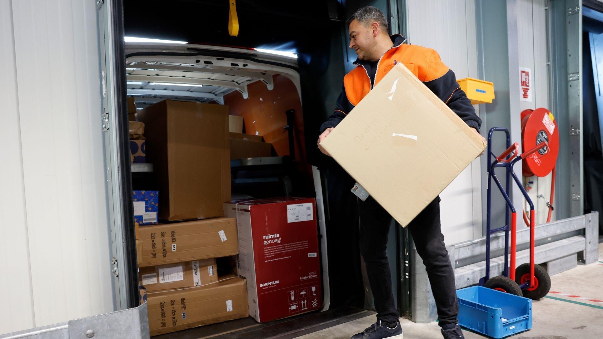 Medewerkers van post- en pakketbezorger PostNL sorteren pakketjes in het pakkettensorteercentrum. Foto: ANP