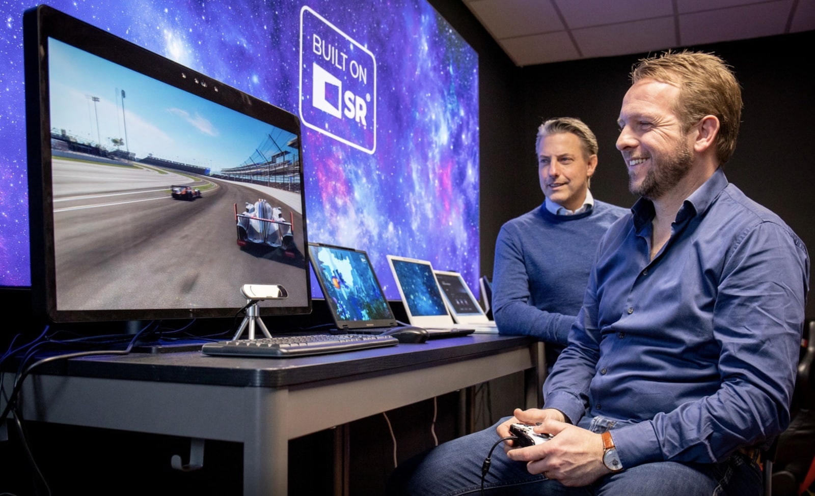 Jochem Taminiau, de commerciële man bij Dimenco, is aan het gamen terwijl algemeen directeur Maarten Tobias toekijkt. Het 3D-beeld is alleen voor de gebruiker zichtbaar en dus niet op de foto te zien. Foto: Doris van Gool/DCI media