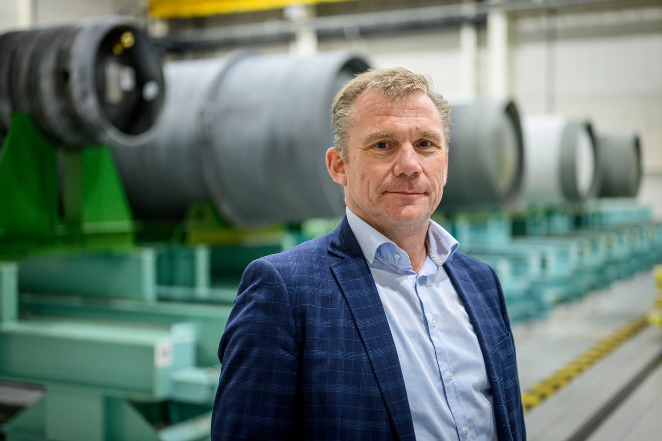 Ad Louter, baas van Urenco, in de hal vol cilinders met uranium dat nog de ultracentrifuges in moet én met verrijkt uranium dat klaar is om naar kerncentrales te worden vervoerd. Foto: Emiel Muijderman.