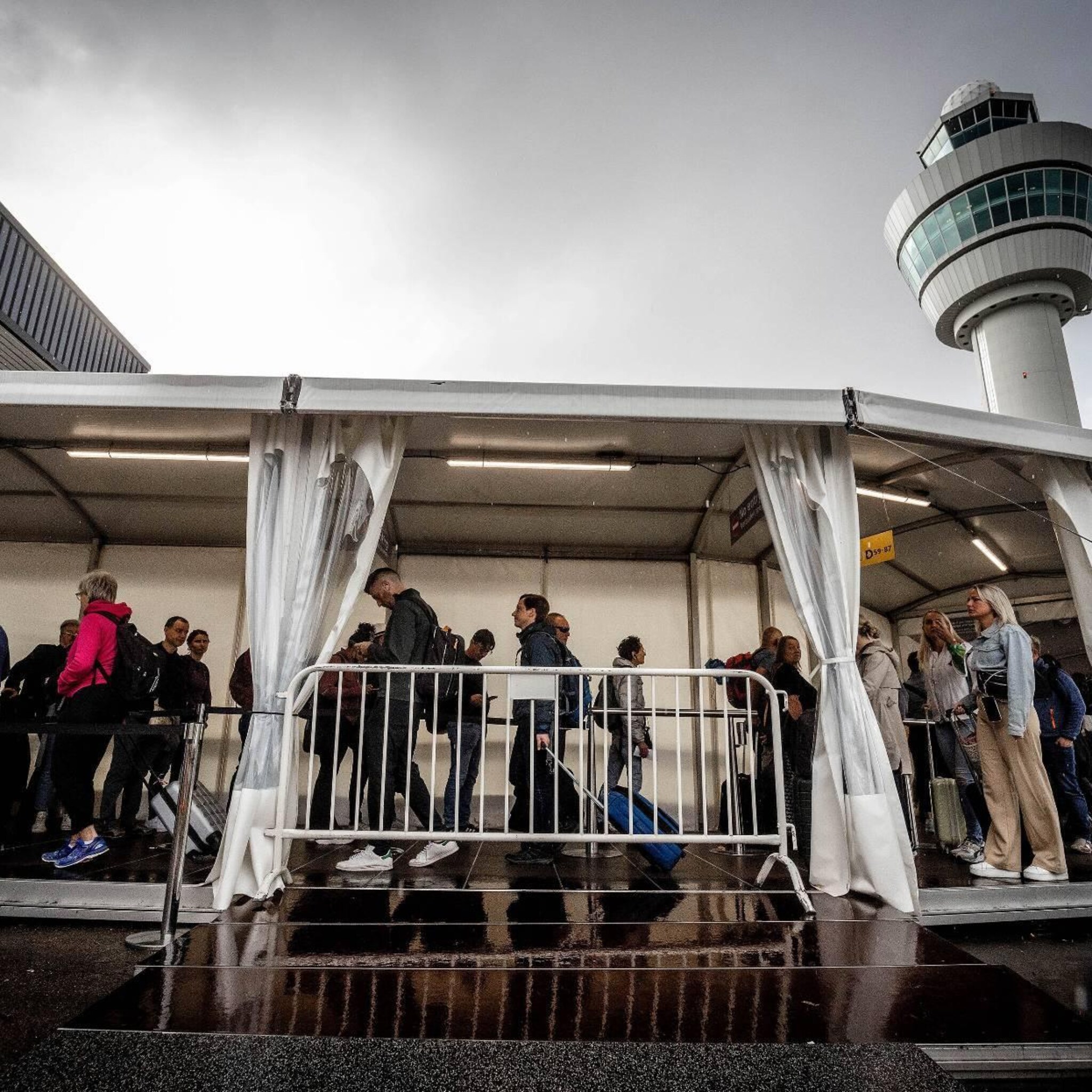 opnieuw rijen op schiphol ook wachtenden onder de overkapping