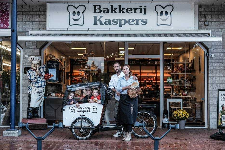 Esther Saalmink met haar man en kinderen voor bakkerij Kaspers. Foto: Jan Ruland van den Brink/De Gelderlander.