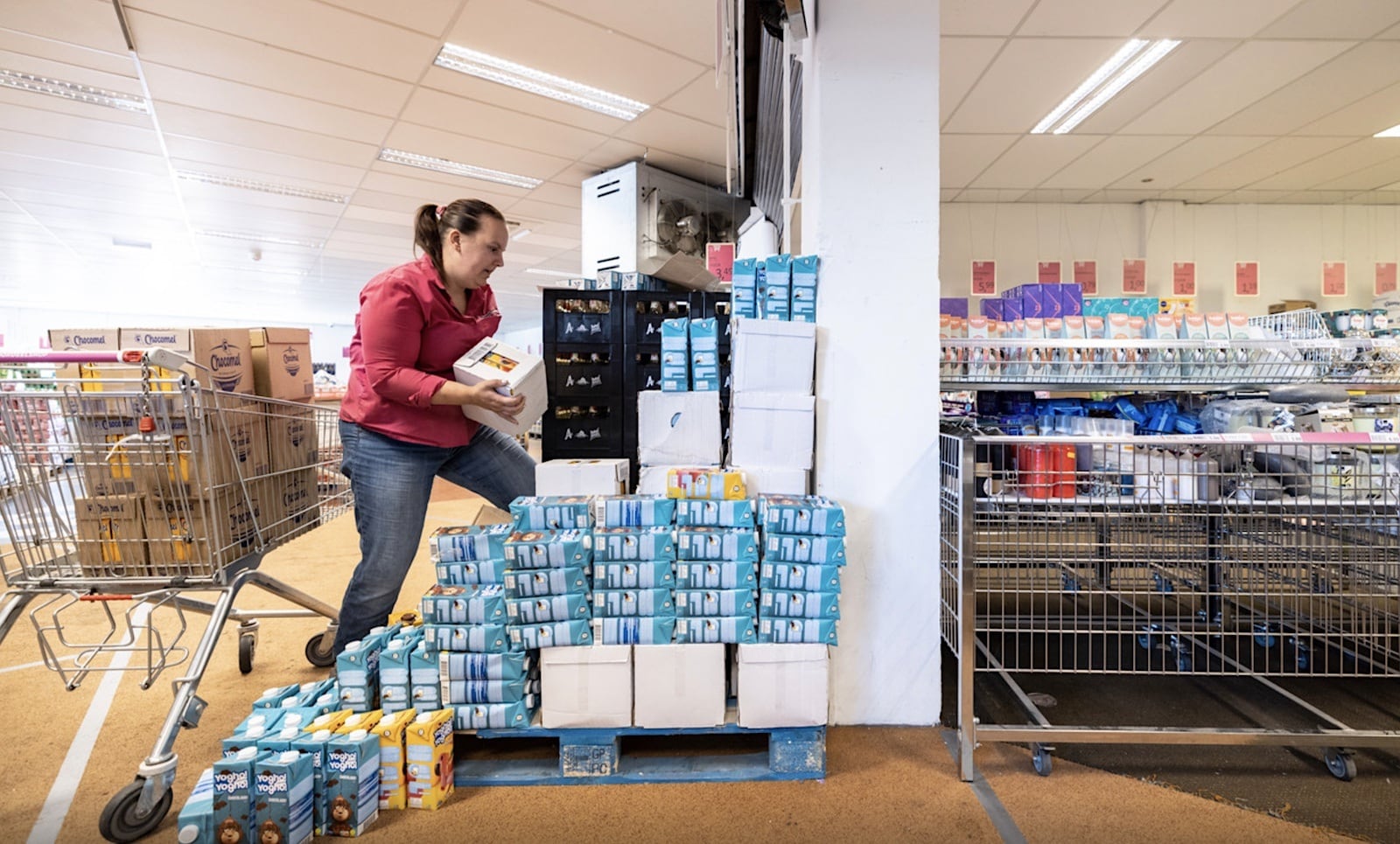 Een medewerker vult de stellingen aan van de Datum Voordeelshop, een winkel waar je over de datum producten kunt shoppen. Foto: Rikkert Harink