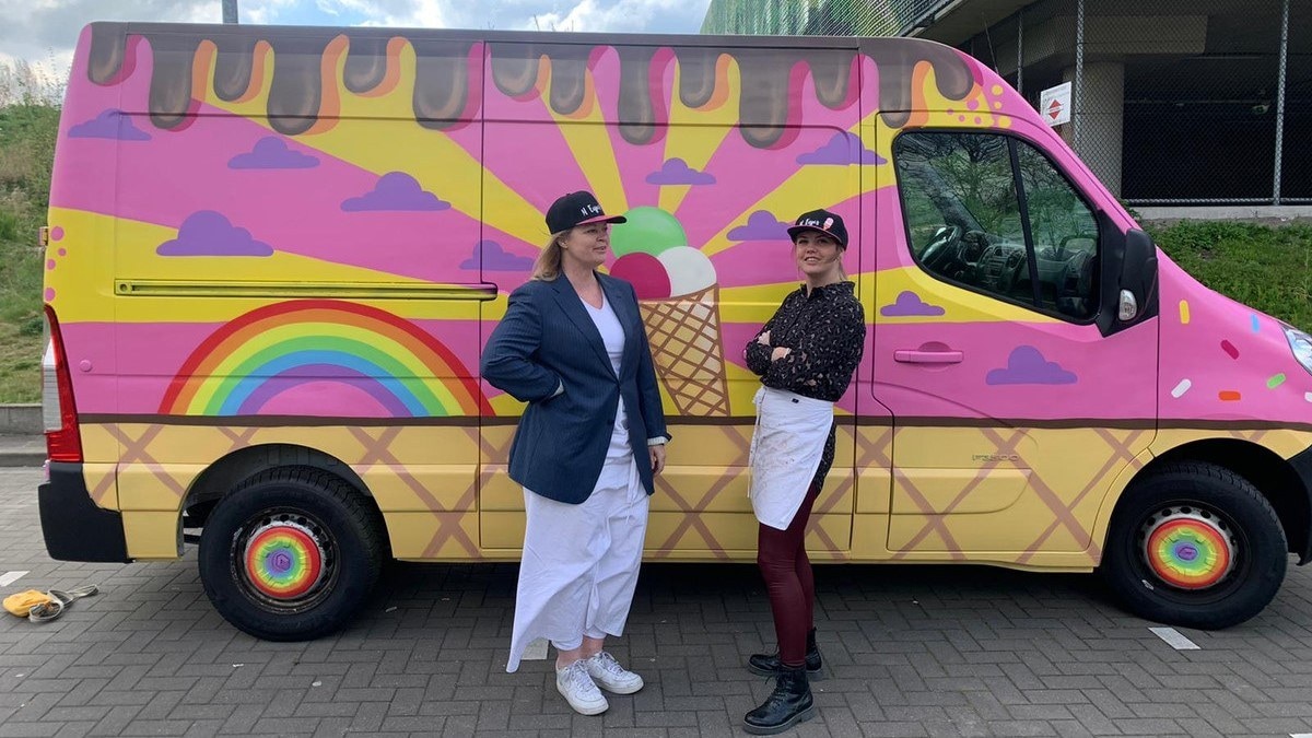 Moeder en dochter bij hun felgekleurde ijscowagen. Foto: Oxalien