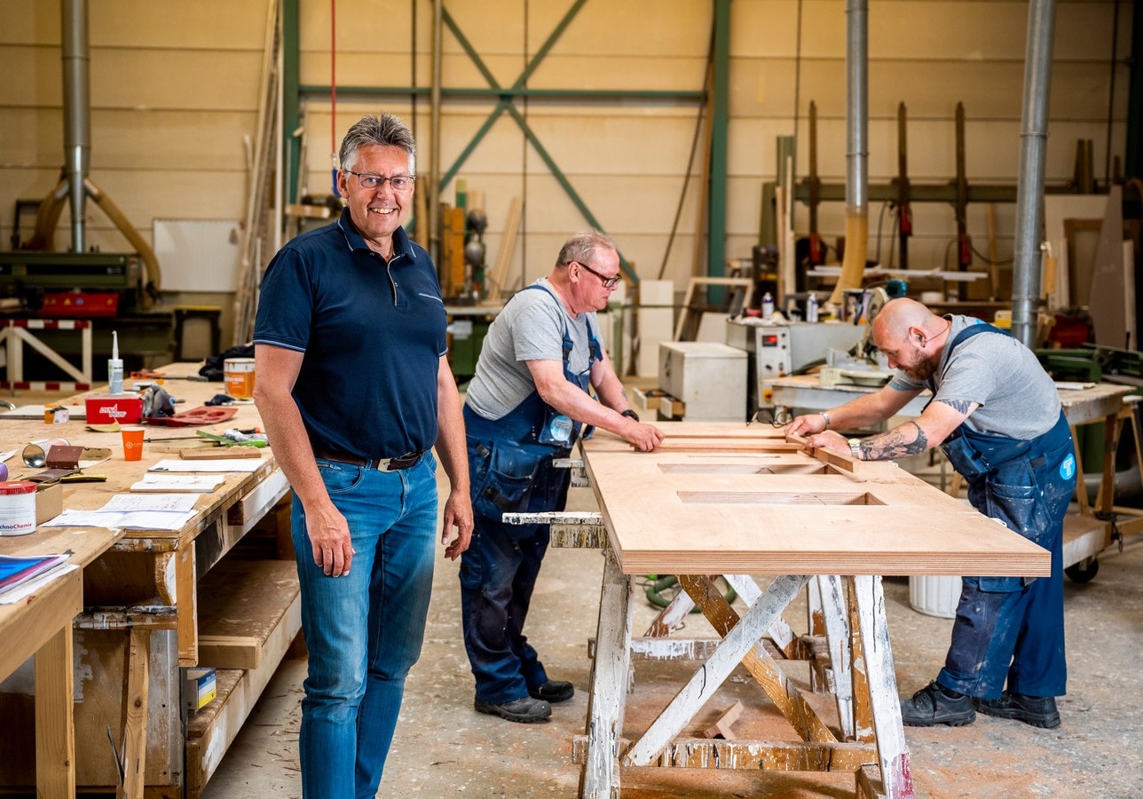 Even een nieuwe deur op maat maken, eerder gesneuveld tijdens een woninginbraak. Ook daar draaien ze bij Tempel Bouw van directeur Hans van Brakel (op de voorgrond) hun hand niet voor om. Foto: Frank de Roo