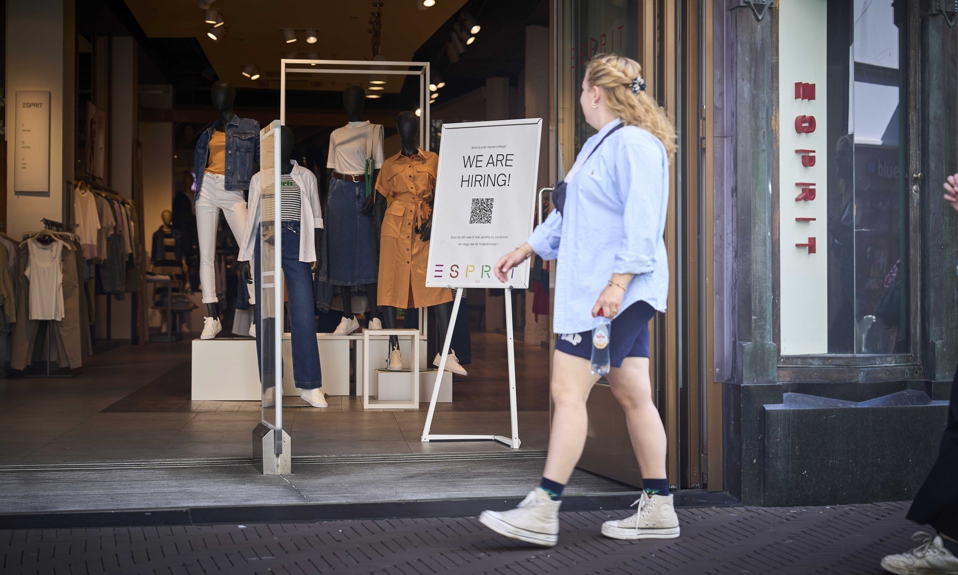 Een Haagse winkel heeft een poster opgehangen om personeel te werven. Foto: ANP