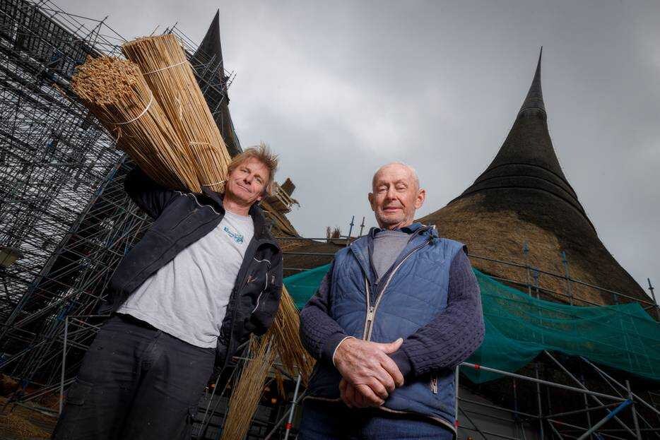 Bep de Gouw (rechts) voorzag de ingang van de Efteling 27 jaar geleden van het grootste rieten dak ter wereld. Deze dagen staat zoon Janne op het dak. Het Huis van de Vijf Zintuigen krijgt een grote opknapbeurt. Foto: Dolph Cantrijn