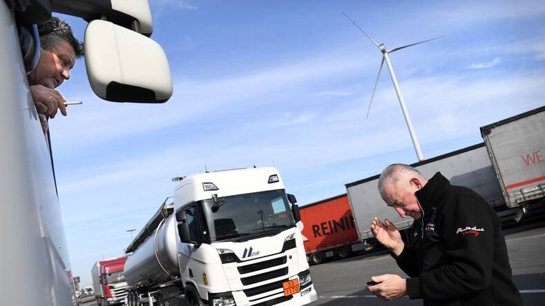 De Oekraïense chauffeur Sergei probeert op parkeerplaats Hazeldonk naar Kiev te bellen. Zijn collega Viktor kijkt toe. Foto: Marcel van den Bergh.
