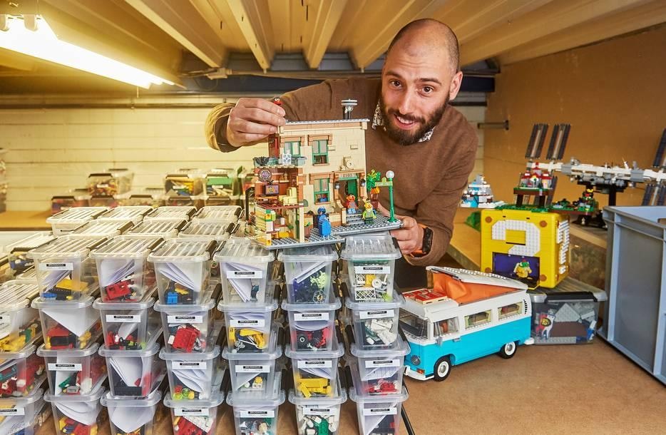 Wesley Bakker in de opslag van zijn Bricks Aholic-magazijn vol Lego. Op de voorgrond een paar grote projecten zoals het Sesamstraat-huis en de VW-bus. Foto: AD/Van Assendelft Fotografie.