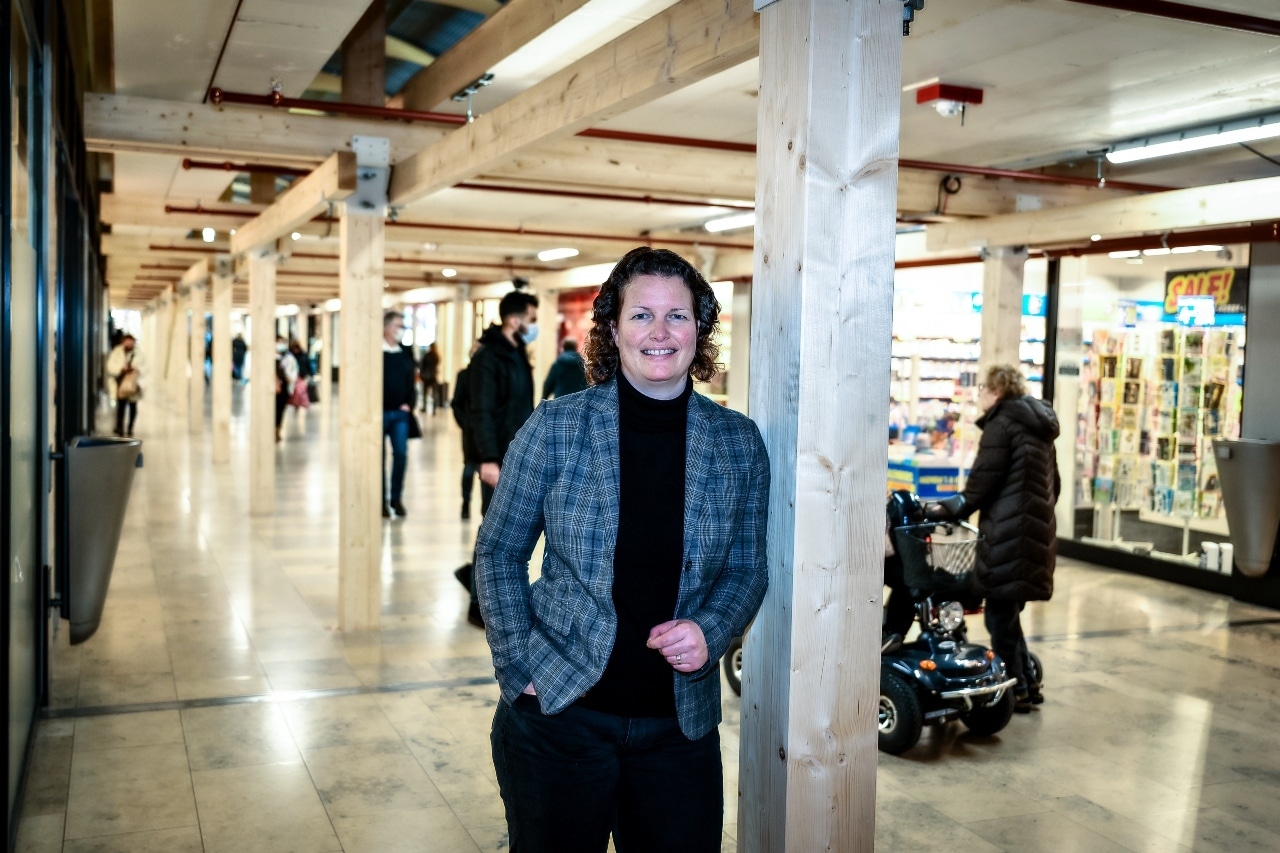 Directeur Karin Laumans bij de houten constructie in het winkelcentrum, nodig om de klus aan het dak te kunnen verrichten. 'Wij zorgen ervoor dat de zonnestralen er juist weer in kunnen'. Foto: Jan Kok