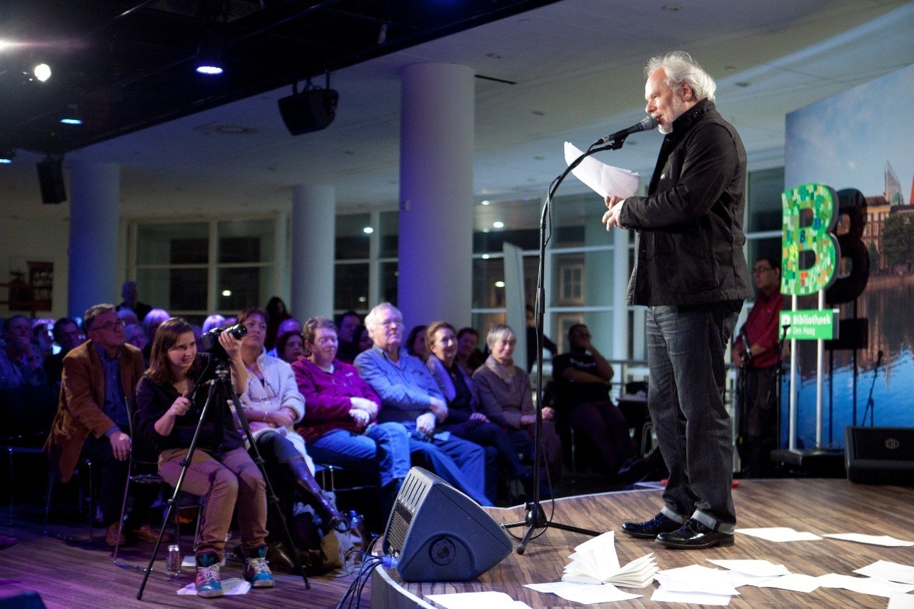 Nico Dijkshoorn natuurlijk, toch ook voor die mevrouw in het paars op rij 1, tijdens dé slotvoorstelling van Poëzie op Pootjes, een Haags gedichteninzamelingsproject, in de Centrale Bibliotheek. Foto: ANP.