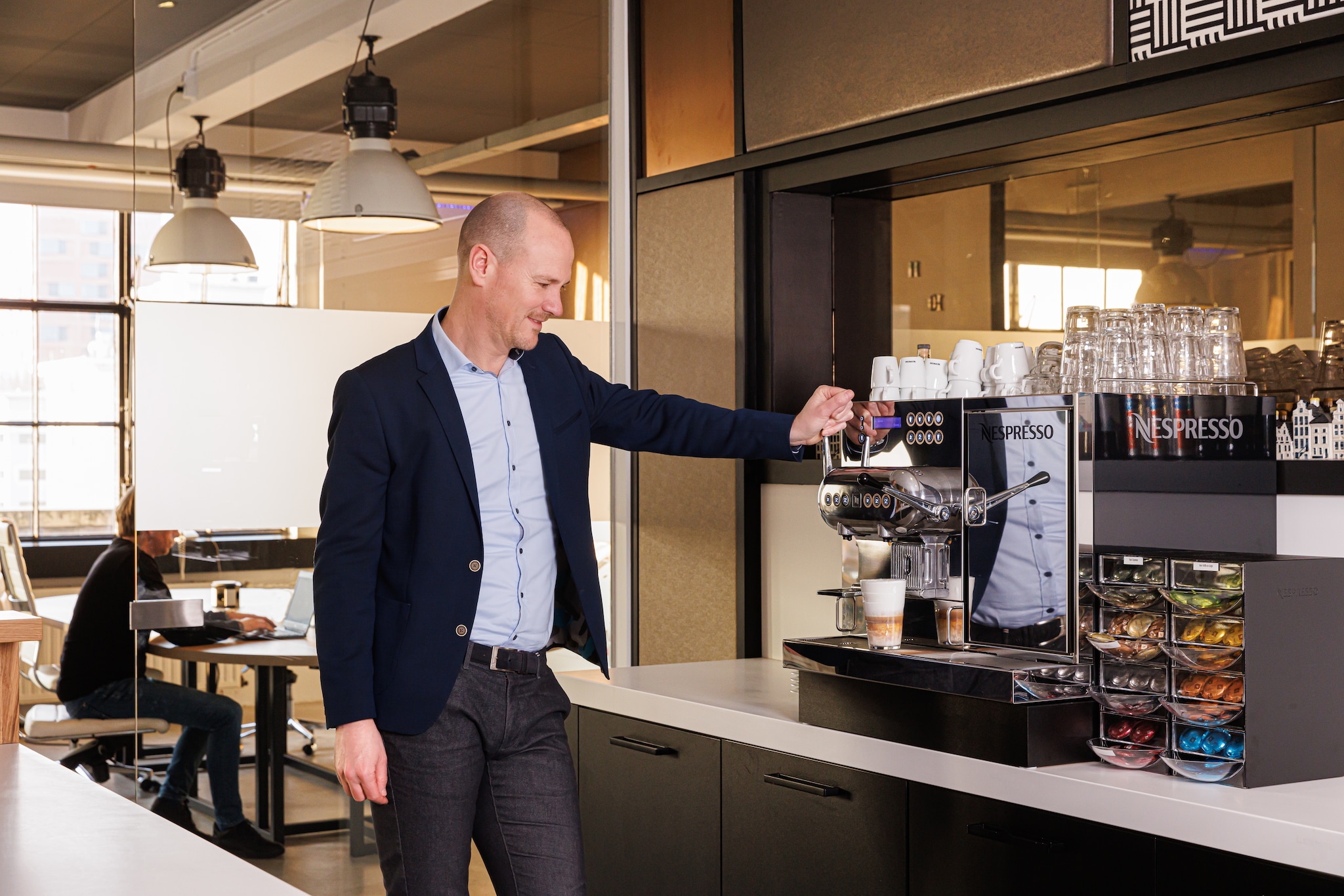Martijn de Coninck bij het professionele koffieapparaat op kantoor bij McCoy &amp; partners in Eindhoven. ,,Koffie drinken en bijkletsen aan het barretje is ook verbinding. Het is net zo goed werken als deelnemen aan een meeting.''