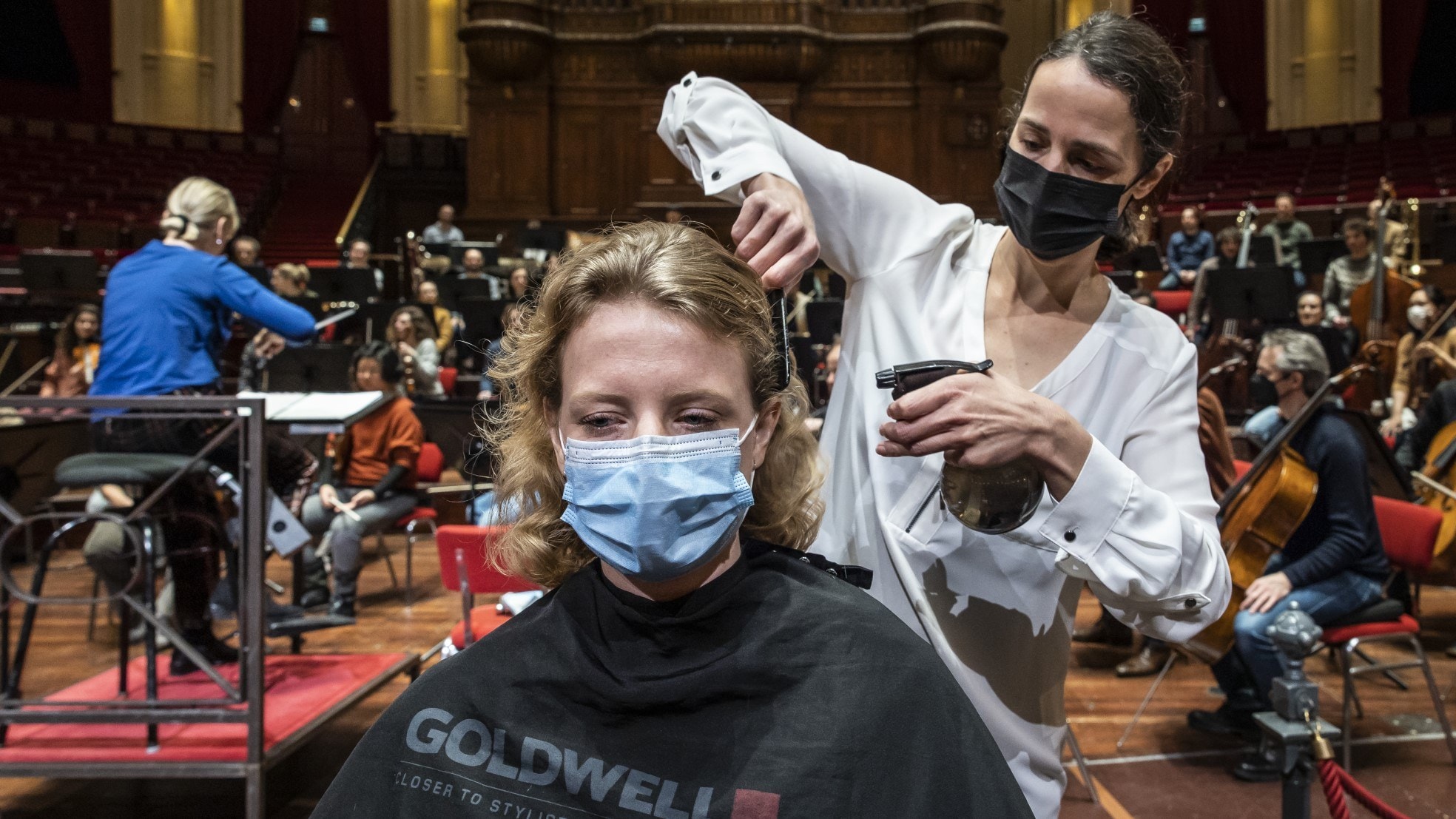 Kappers knippen op het podium van het Concertgebouw klanten terwijl het Concertgebouworkest repeteert. Foto: ANP