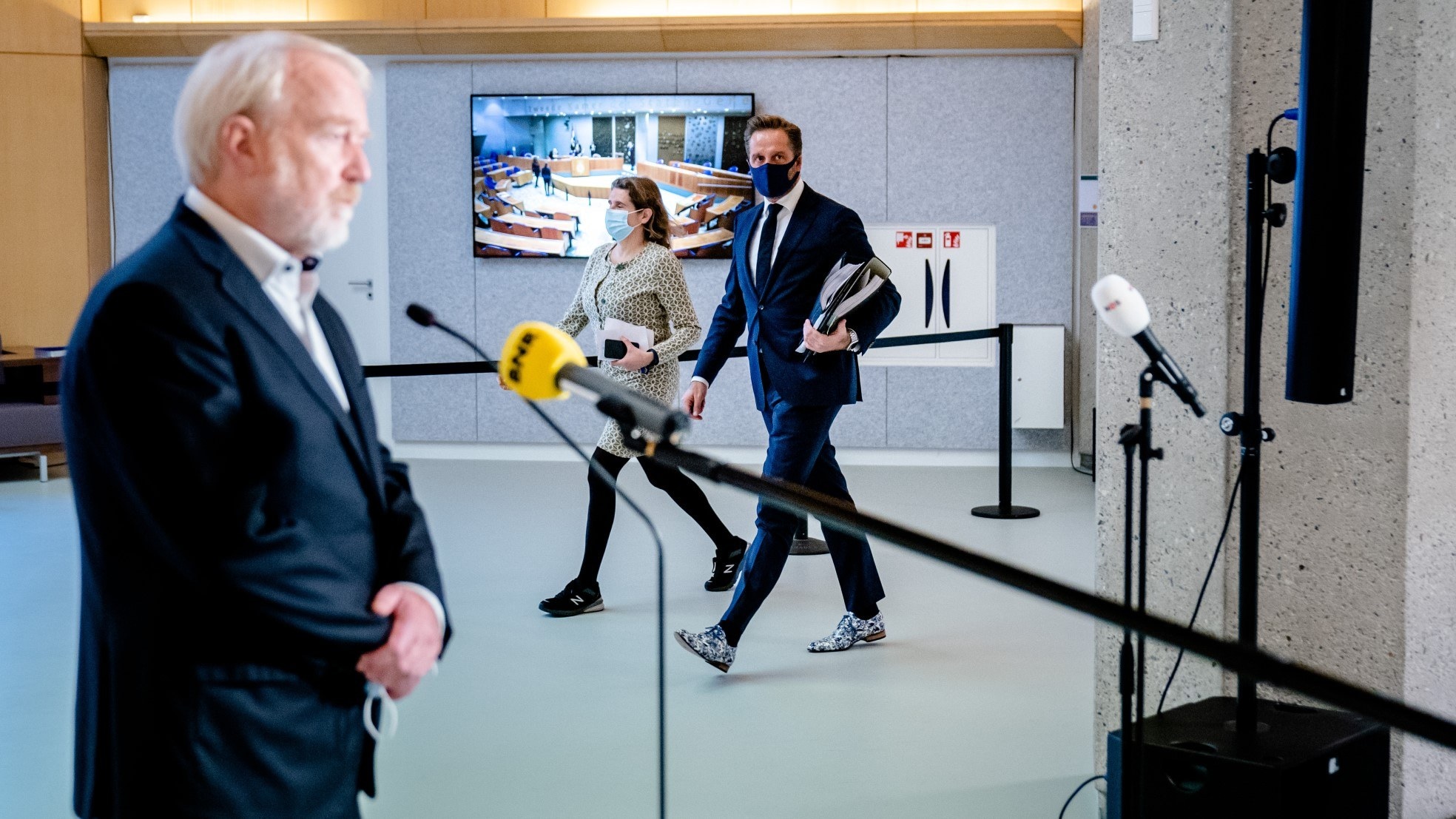 Demissionair minister Hugo de Jonge van Volksgezondheid passeert OMT-voorzitter Jaap van Dissel op weg naar een coronadebat. Foto: ANP