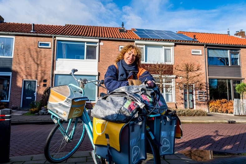 Postbezorger Anita Rabbett kijkt uit naar de drukte bij PostNL in december. ,,Ik wil de mensen graag die mooie momenten bezorgen.’’ Foto: Jan Kok.