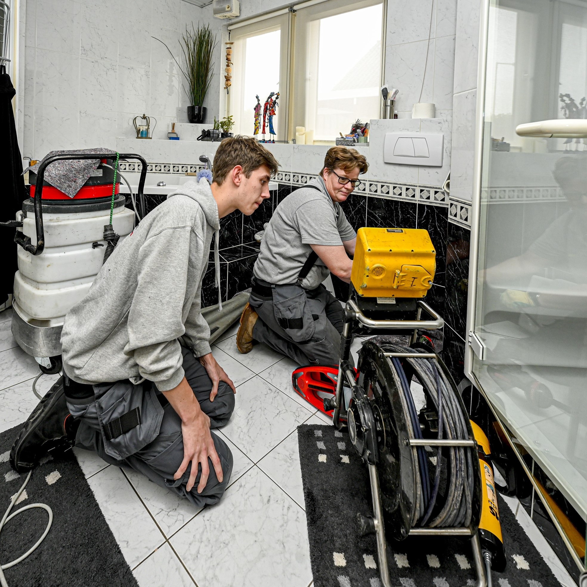 Nelson (op de voorgrond) is één van die leerlingen bij de door Kornee van Terheijden zelf opgezette opleiding voor riooltechniek. Meelopen met de medewerkers - in dit geval Wies Snijders - maakt er onderdeel van uit. Foto: Pix4Profs/Peter Braakmann