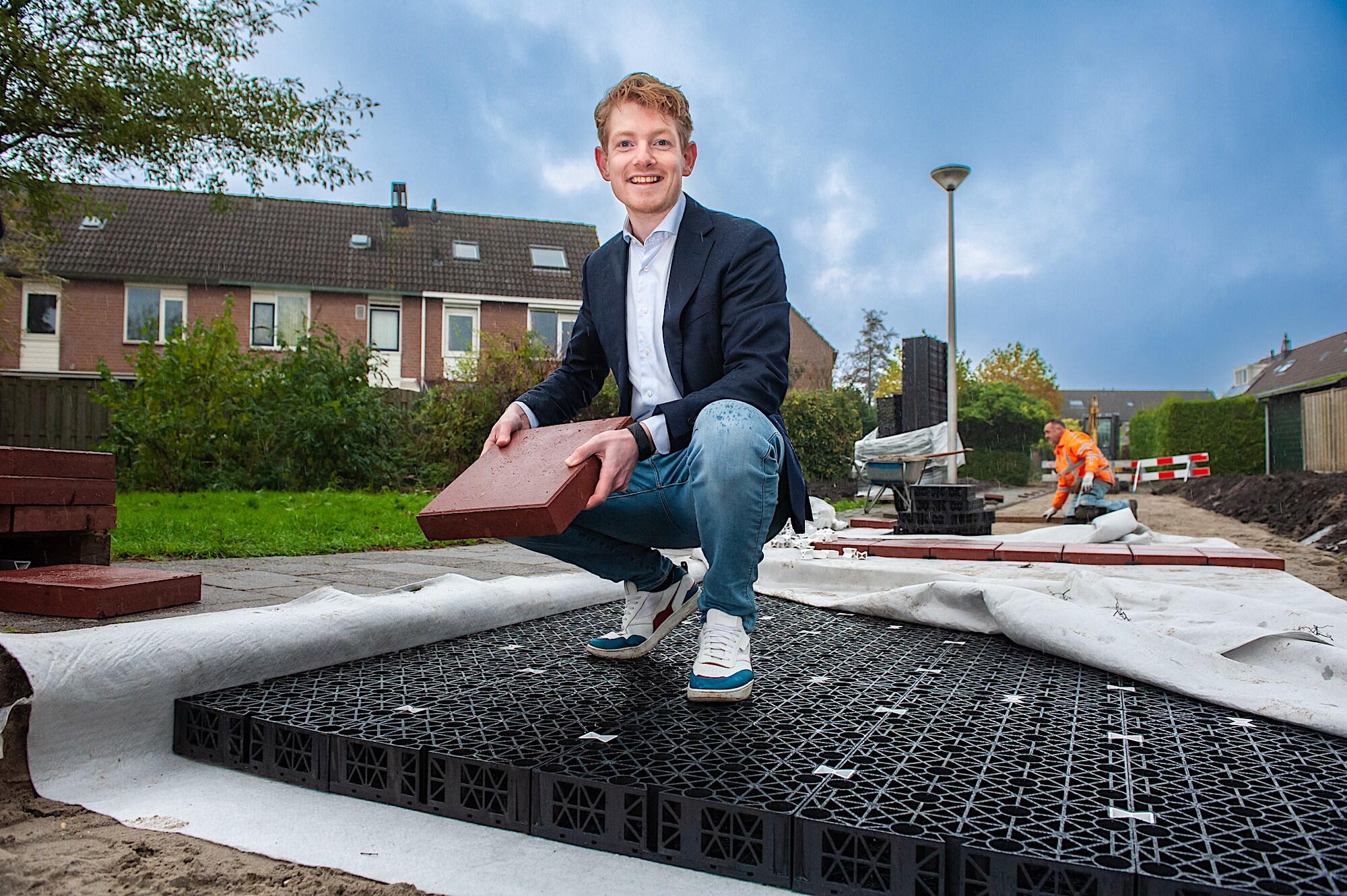 Erwin van der Zwaag met zijn bestratingssysteem van speciale tegels, een waterreservoir en doek. Hiermee wordt bij regen water opgevangen en overlast voorkomen. Foto: Sandra Zeilstra