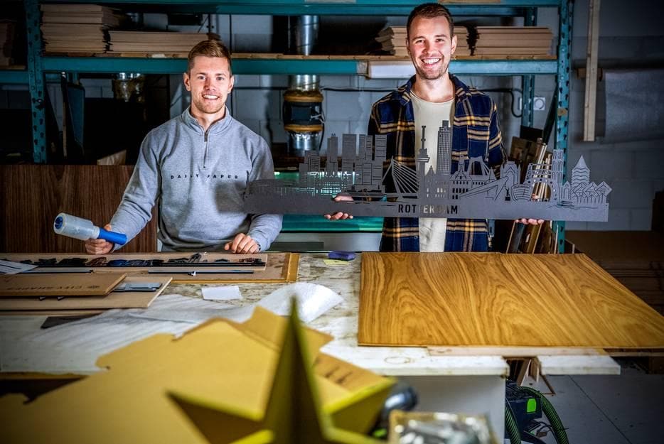 Broers Chris (links) en Tim Clay in hun werkplaats van City Shapes in Hoogvliet waar zij onder andere houten skylines en stadsplattegronden maken. Foto'a: AD/Frank de Roo.