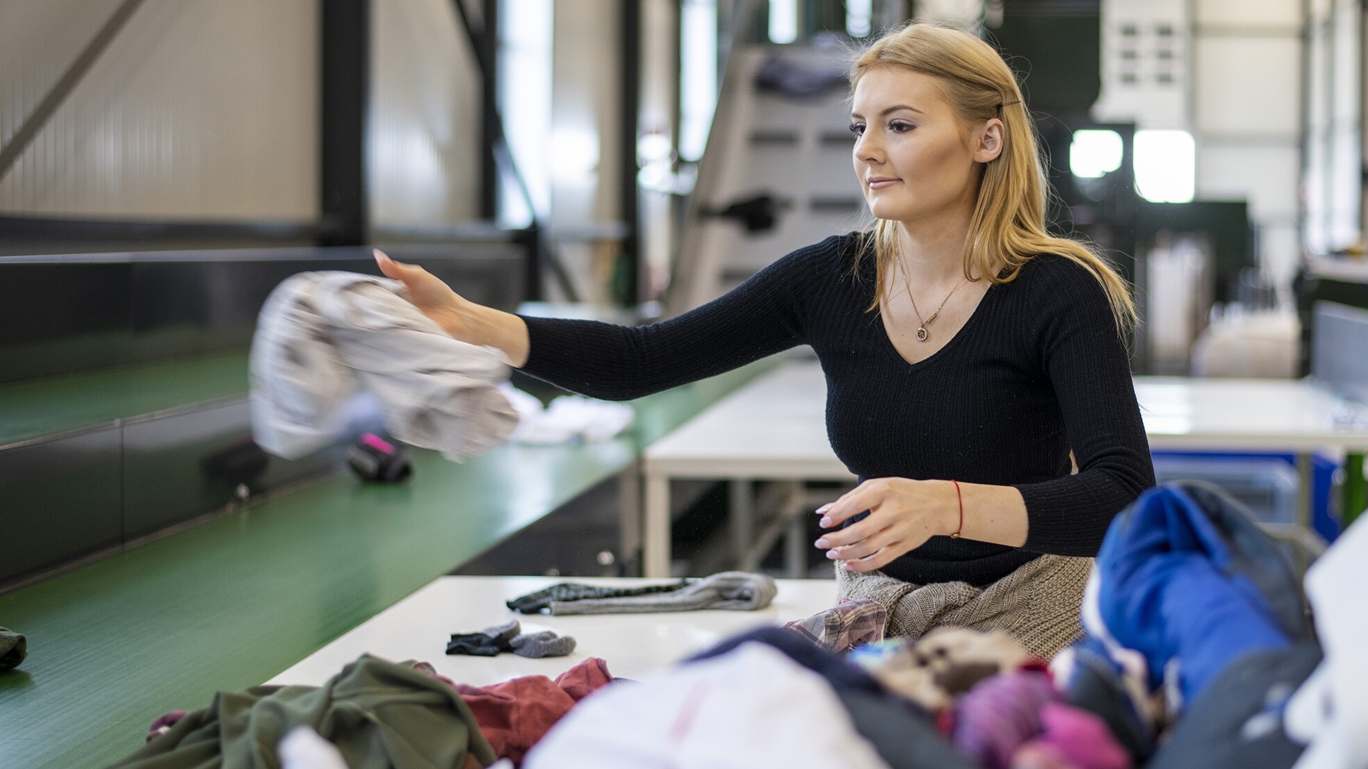 Persoon aan het werk op textielsorteercentrum voor herdraagbaar en niet-herdraagbaar textiel. Afbeelding ter illustraite, persoon komt niet in het verhaal terug. Bron: ANP.