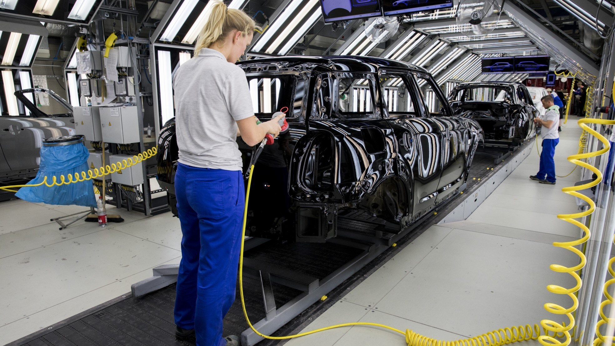 Medewerkers bij een assemblagelijn van Mini's bij autofabrikant VDL Nedcar in Born. Foto: ANP