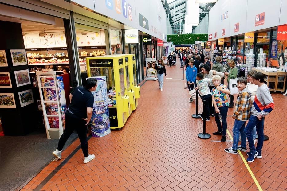 Lange rij wachtenden voor de succesvolle Pokémonwinkel in Shoppingcenter Overvecht.
