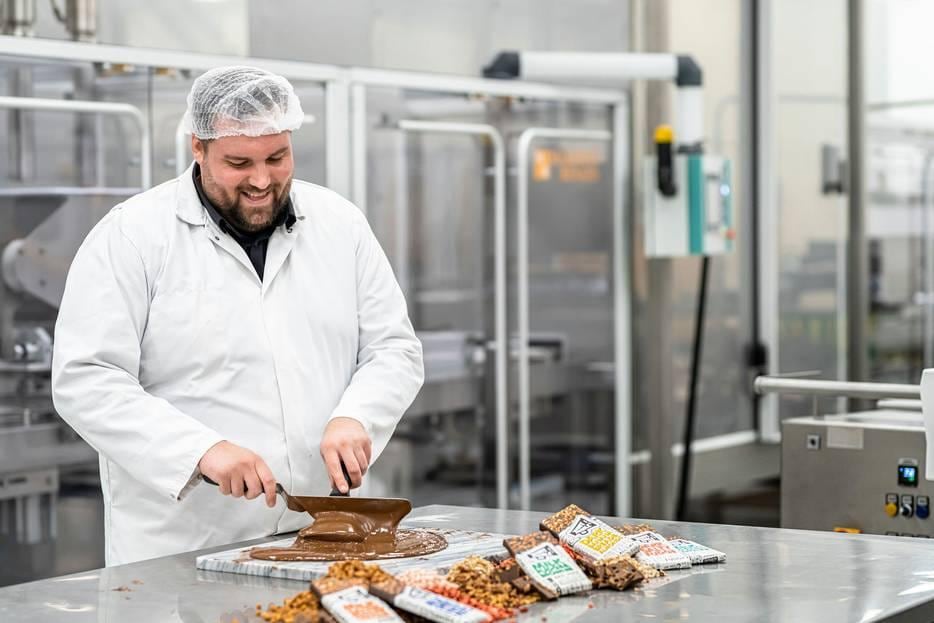 Joshua Schaap, de Willy Wonka van chocolademerk Johnny Doodle, in actie. Wereldwijd likken liefhebbers hun vingers erbij af, maar de repen worden gemaakt in de Hoeksche Waard. Foto: AD/Jordi Sloots.