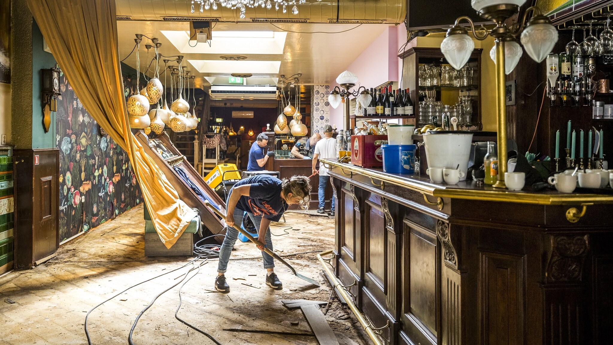 Inwoners ruimen puin in een horecazaak in Valkenburg aan de Geul. Foto: ANP
