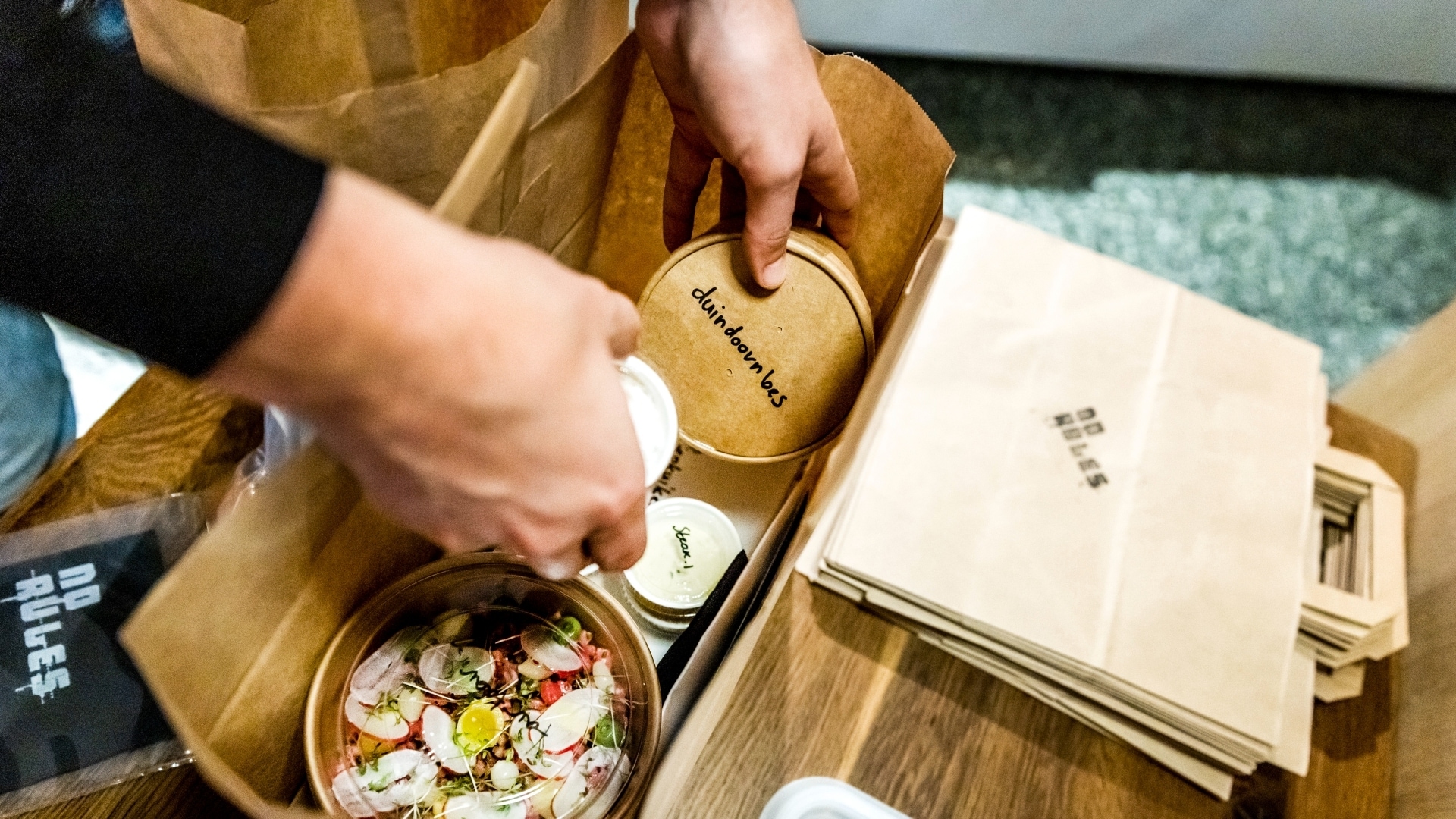 Een steeds vaker terugkerend beeld: restaurants die maaltijden inpakken om te bezorgen. Foto: ANP