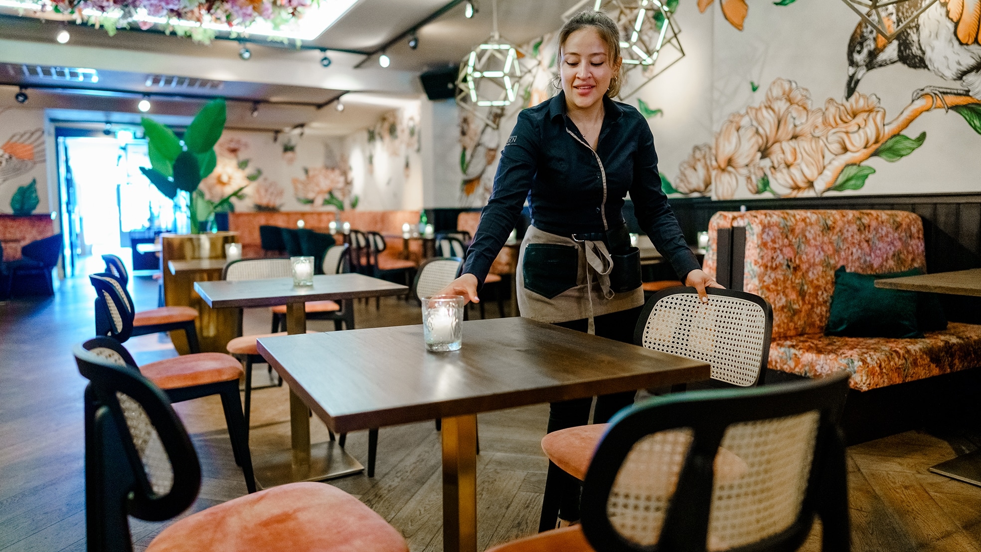 Een werknemer van het Haagse restaurant Luden treft voorbereidingen voor de versoepelde maatregelen. Foto: ANP