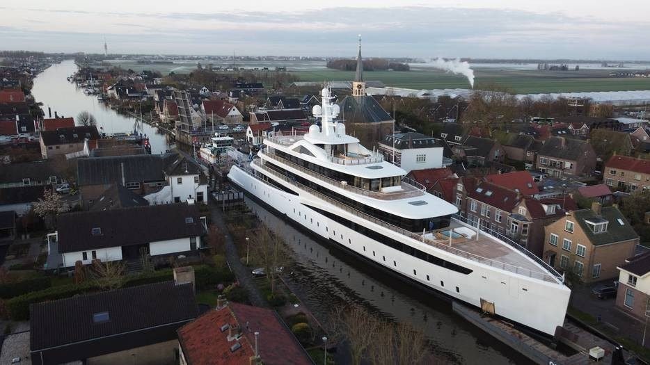 Een 94 meter lang megajacht van jachtbouwer Feadship van Lent manoeuvreert, onderweg naar de haven van Rotterdam, door de wateren van Alphen aan den Rijn. Foto: Videostill