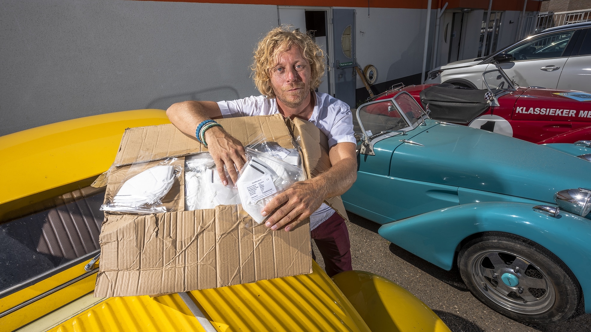 Iwan Göbel voor een paar Burtons, sportwagens op het onderstel van een lelijke eend. Voor hem dozen vol mondkapjes, die hij vorig jaar naar Nederland haalde via contacten die hij opdeed met zijn sportautofabriek in Zutphen Foto: Jeroen Jazet