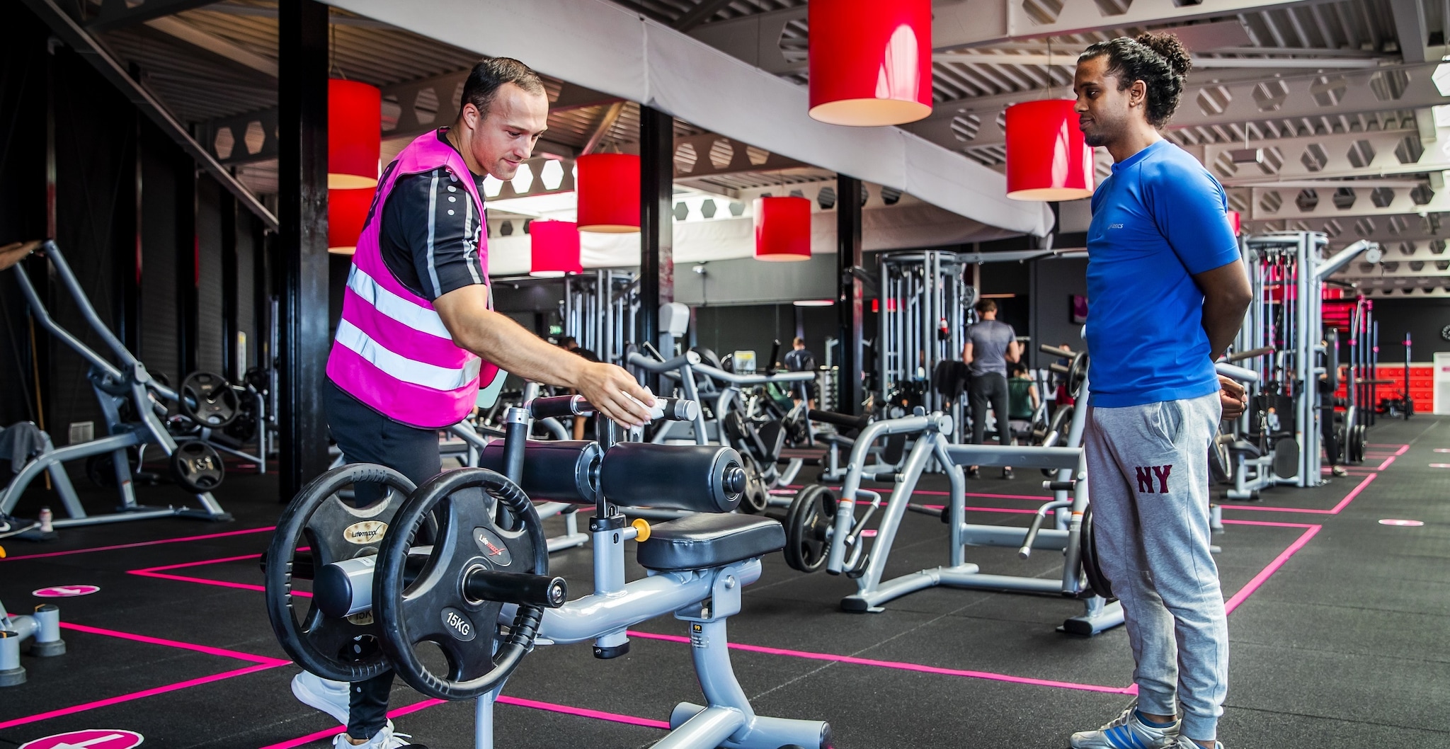 Een medewerker maakt een fitnessapparaat schoon in de zomer van 2020, toen de sportscholen weer tijdelijk opengingen. Foto: ANP