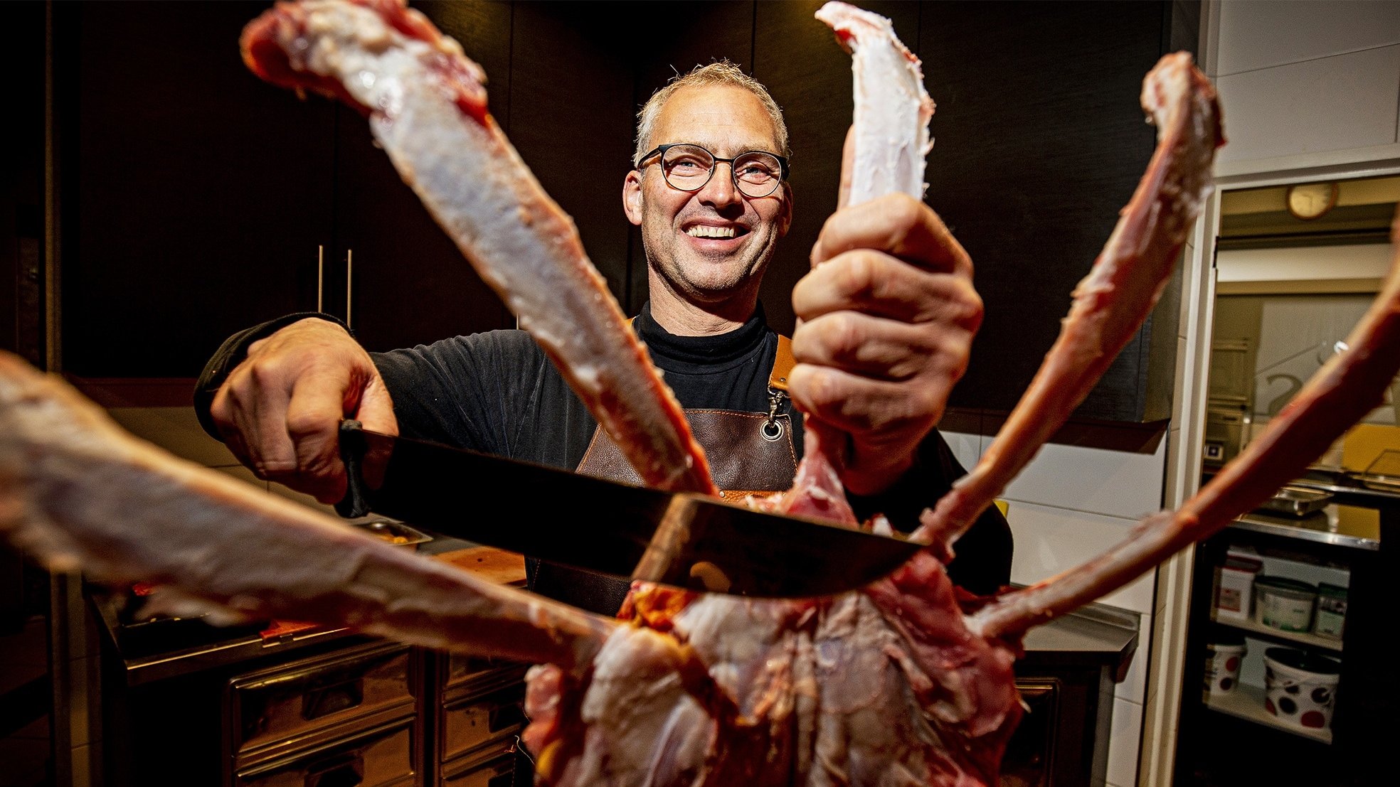 Slager Koos van Essen van slagerij Warmenhoven uit Wateringen snijdt een lamsrack XL aan stukken in zijn slagerij. Dit stuk tomahawk vlees is populair bij BBQ-liefhebbers. Foto: Guus Schoonewille